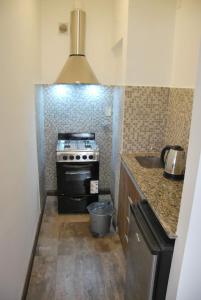 a small kitchen with a stove and a sink at Sur Hotel in Necochea