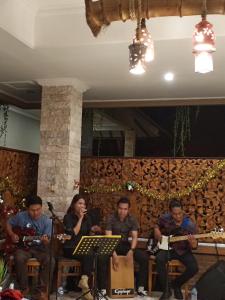 a group of people sitting in a room playing instruments at Sea Breeze Candidasa in Candidasa