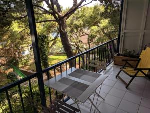 un balcón con mesa, sillas y un árbol en Green Coast, en Sounio