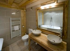Un baño con dos lavabos, un inodoro y una bañera. en Chalet Tarine, en Bourg-Saint-Maurice