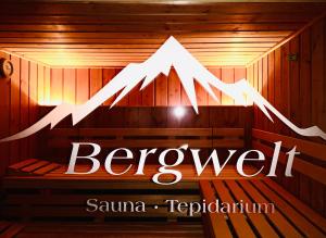 a sign in a sauna with a mountain on it at Haus Bergwelt - Appartements in Lech am Arlberg