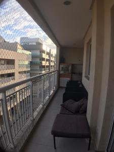 a balcony with two couches and a view of a building at Mediterrâneo 507 - Todo Equipado, Ar Condicionado, Churrasqueira na Varanda, Internet Fibra 600MB, Estacionamento Grátis in Cabo Frio
