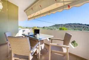 a balcony with a table with chairs and a laptop on it at Villa Oliva in Astris