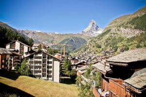 Vistas a una ciudad con una montaña en el fondo en Haus Belmont en Zermatt