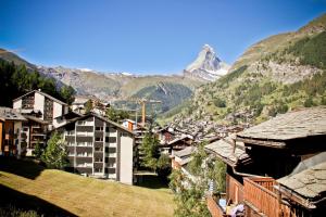 Vistas a una ciudad con una montaña en el fondo en Haus Belmont, en Zermatt
