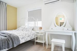 a white bedroom with a bed and a mirror at Beautiful Villa in Shinjuku Shin-OKubo 5minutes walk in Tokyo