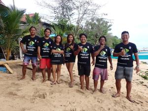 a group of people wearing tshirts on the beach at 4 Sisters Divers in Bunaken