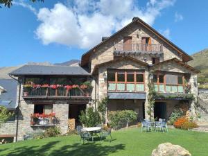 a house with tables and chairs in front of it at Hotel Ca de Graus in Castanesa