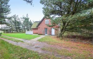 a red brick house with a tree and a dirt road at Holiday Home Lejrbjergvej Rømø X in Rømø Kirkeby