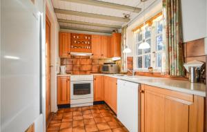 a kitchen with wooden cabinets and a white stove top oven at Holiday Home Lejrbjergvej Rømø X in Rømø Kirkeby