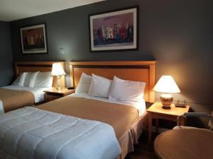 a hotel room with two beds and two lamps at Metro Inn in Victoria