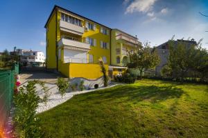 ein gelbes Gebäude mit einem Hof davor in der Unterkunft Apartment Marica in Pula