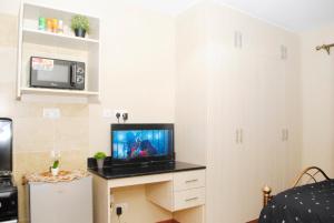 a small living room with a tv and a microwave at WEST SUITES SHERRY HOMES in Nairobi