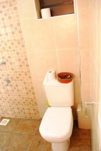a bathroom with a toilet with a basket on top of it at WEST SUITES SHERRY HOMES in Nairobi