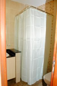 a bathroom with a white shower curtain and a toilet at WEST SUITES SHERRY HOMES in Nairobi