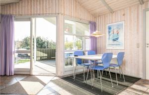 SlettestrandにあるAwesome Home In Fjerritslev With Saunaのダイニングルーム(テーブル、青い椅子付)