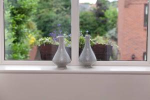 three vases sitting on a window sill with potted plants at RED LION LOFT BLIDWORTH in Blidworth
