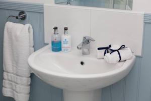 a bathroom sink with two bottles of soap and towels at RED LION LOFT BLIDWORTH in Blidworth