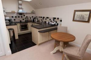 a kitchen with a wooden table and a small table at RED LION LOFT BLIDWORTH in Blidworth