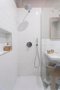 ein weißes Bad mit einer Dusche und einem Waschbecken in der Unterkunft Dimora Toledo in Neapel