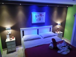 een slaapkamer met een wit bed met een blauwe accentmuur bij B&BProviter in Napels