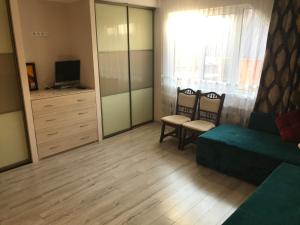 sala de estar con sofá, silla y TV en Садиба Червона калина Private estate Chervona Kalyna, en Yaremche