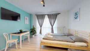 - une chambre avec un lit, un bureau et une télévision dans l'établissement Studio steps from Nivy & Main Bus Station, à Bratislava