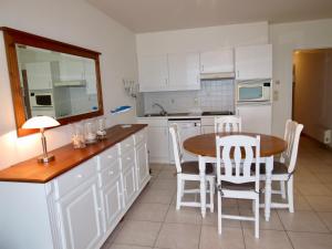 een keuken met een houten tafel en witte kasten bij Residentie Zeezicht I in Oostende