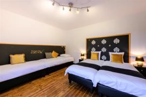 una camera con tre letti con cuscini bianchi e gialli di Zythogite Appartement 9 personnes, jardin, bbq a Tintigny