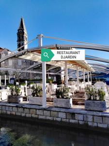 a sign for a restaurant near the water at Apartment Mediterraneo Blue Sky in Perast