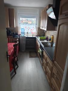 a kitchen with wooden cabinets and a sink and a window at Ferienunterkunft - Am Stadtgarten in Saarlouis