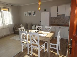 a kitchen and dining room with a table and chairs at Apartament Konda in Białka Tatrzańska