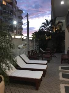 a patio with chaise lounges on a building at Mediterrâneo 507 - Todo Equipado, Ar Condicionado, Churrasqueira na Varanda, Internet Fibra 600MB, Estacionamento Grátis in Cabo Frio