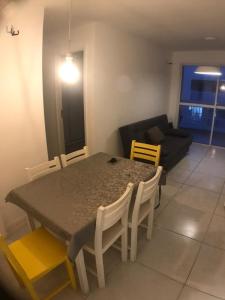a table and chairs in a living room with a couch at Mediterrâneo 507 - Todo Equipado, Ar Condicionado, Churrasqueira na Varanda, Internet Fibra 600MB, Estacionamento Grátis in Cabo Frio