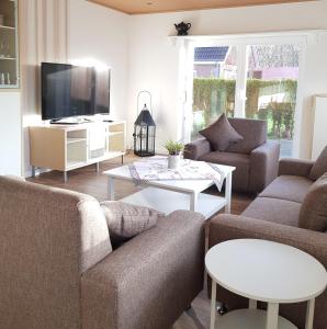 ein Wohnzimmer mit 2 Sofas und einem TV in der Unterkunft Ferienhaus Käthchen am Deich vor den Toren von Sylt in Emmelsbüll-Horsbüll