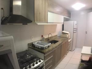 a kitchen with a sink and a stove and a refrigerator at Mediterrâneo 507 - Todo Equipado, Ar Condicionado, Churrasqueira na Varanda, Internet Fibra 600MB, Estacionamento Grátis in Cabo Frio