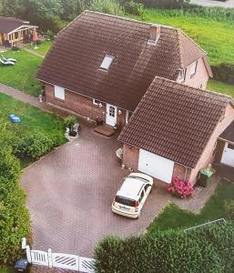 une voiture garée devant une maison dans l'établissement Ferienhaus Käthchen am Deich vor den Toren von Sylt, à Emmelsbüll-Horsbüll