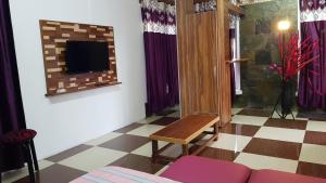 uma sala de estar com um sofá e uma televisão na parede em Affa Tourist Residence em Souillac