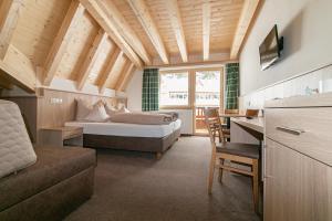 a bedroom with a bed and a desk in a room at S`Hoamatl in Obergurgl