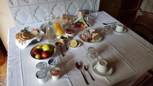 uma mesa com uma toalha de mesa branca com alimentos para o pequeno-almoço em B&B ABETE BIANCO em Auronzo di Cadore