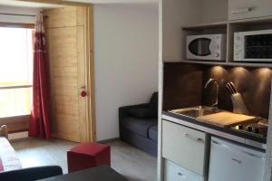 a kitchen with a sink and a couch in a room at val thorens appartement 4 personnes ski aux pieds in Val Thorens