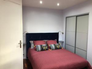 1 dormitorio con 1 cama con sábanas y almohadas rojas en appartement vue mer, en Cannes