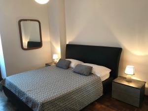 ein Schlafzimmer mit einem Bett mit zwei Kissen und einem Spiegel in der Unterkunft Appartamento Lake Como in Gravedona