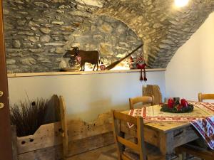 ein Esszimmer mit einem Tisch und einer Steinmauer in der Unterkunft Maison Lucien in Gignod