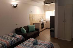 uma sala de estar com um sofá e uma cozinha em 23 Manzini Chalets-Pumba's Den em St. Lucia