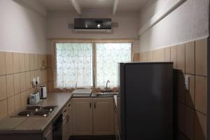 uma cozinha com um frigorífico preto e uma janela em 23 Manzini Chalets-Pumba's Den em St. Lucia