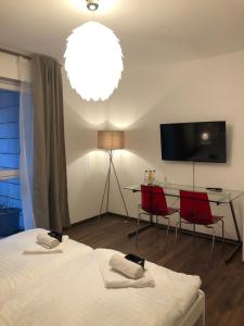 um quarto com uma cama, uma mesa e uma televisão em New Private Rooms Fuerth em Fürth
