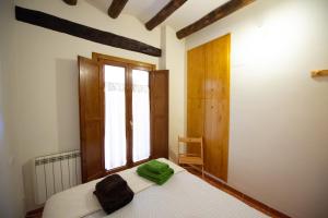 um quarto com uma cama num quarto com uma janela em Apartamentos Aguilar em Alcañiz