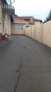 an empty parking lot next to a fence at The Crescent Guesthouse on Waterfall in Durban