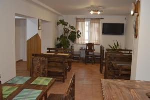 uma sala de jantar com mesas e cadeiras de madeira em Садиба "Мапа" em Berehove